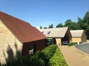 view of two buildings completed in cedar shakes and one in tiles by Kingsley Roofing