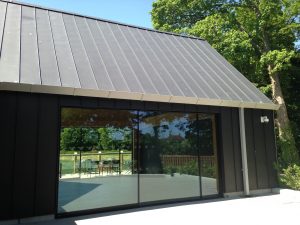Pitched standing seam Zinc roof and black Zinc vertical cladding completed by Kingsley Roofing at the open air museum in Chichester.